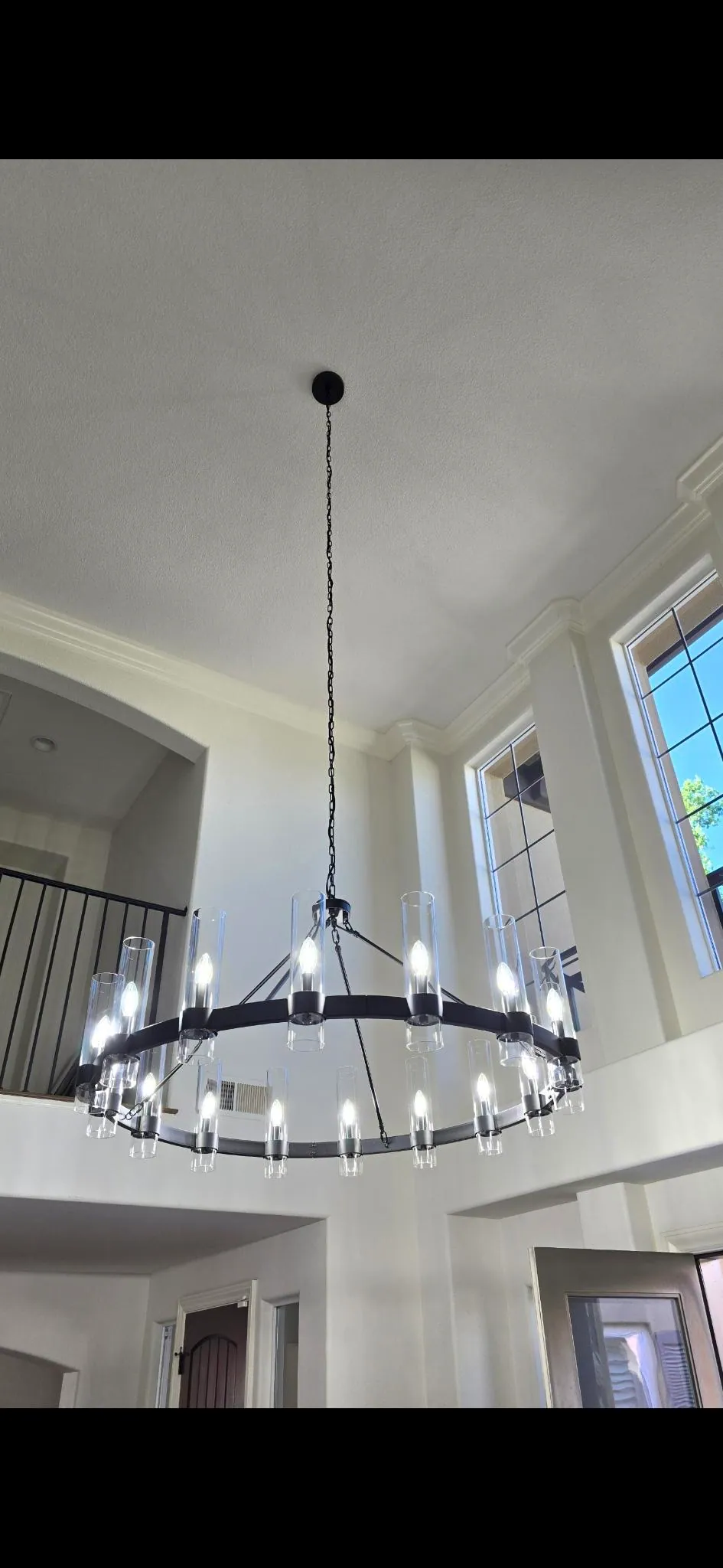 Large statement chandelier installed in a high-ceiling entry