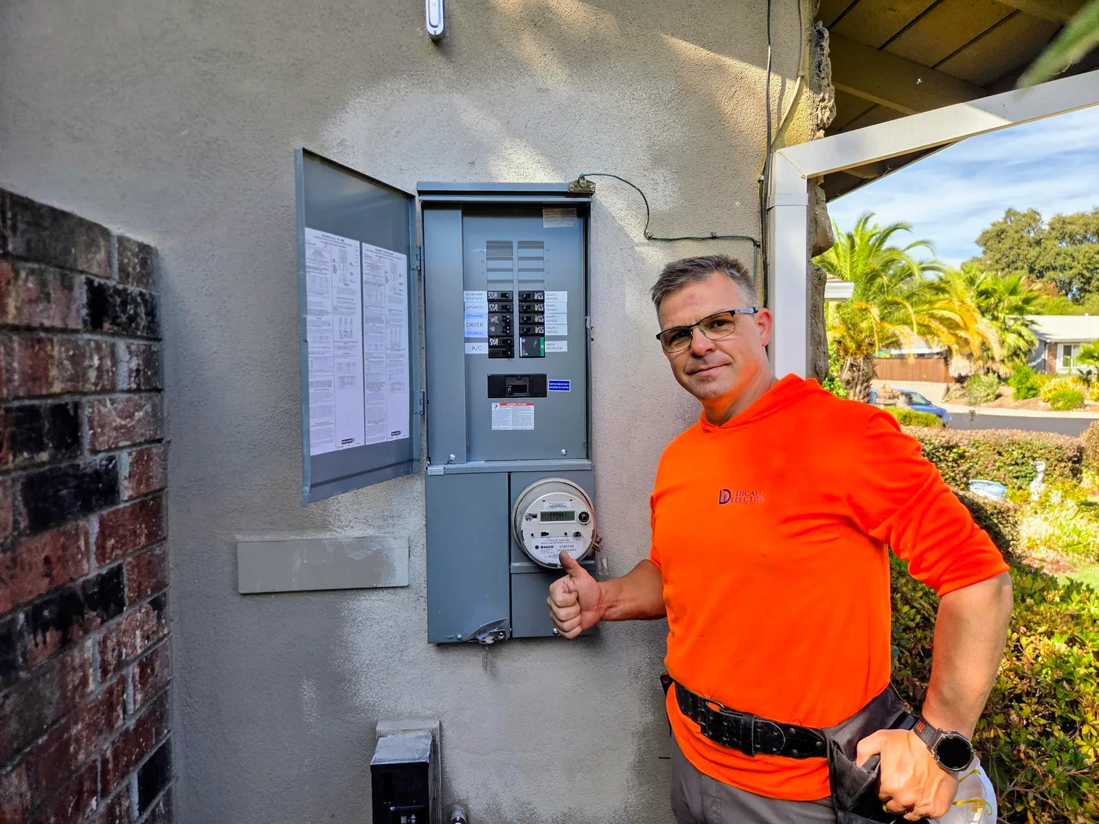 Dican Electric technician beside a newly installed home electrical panel
