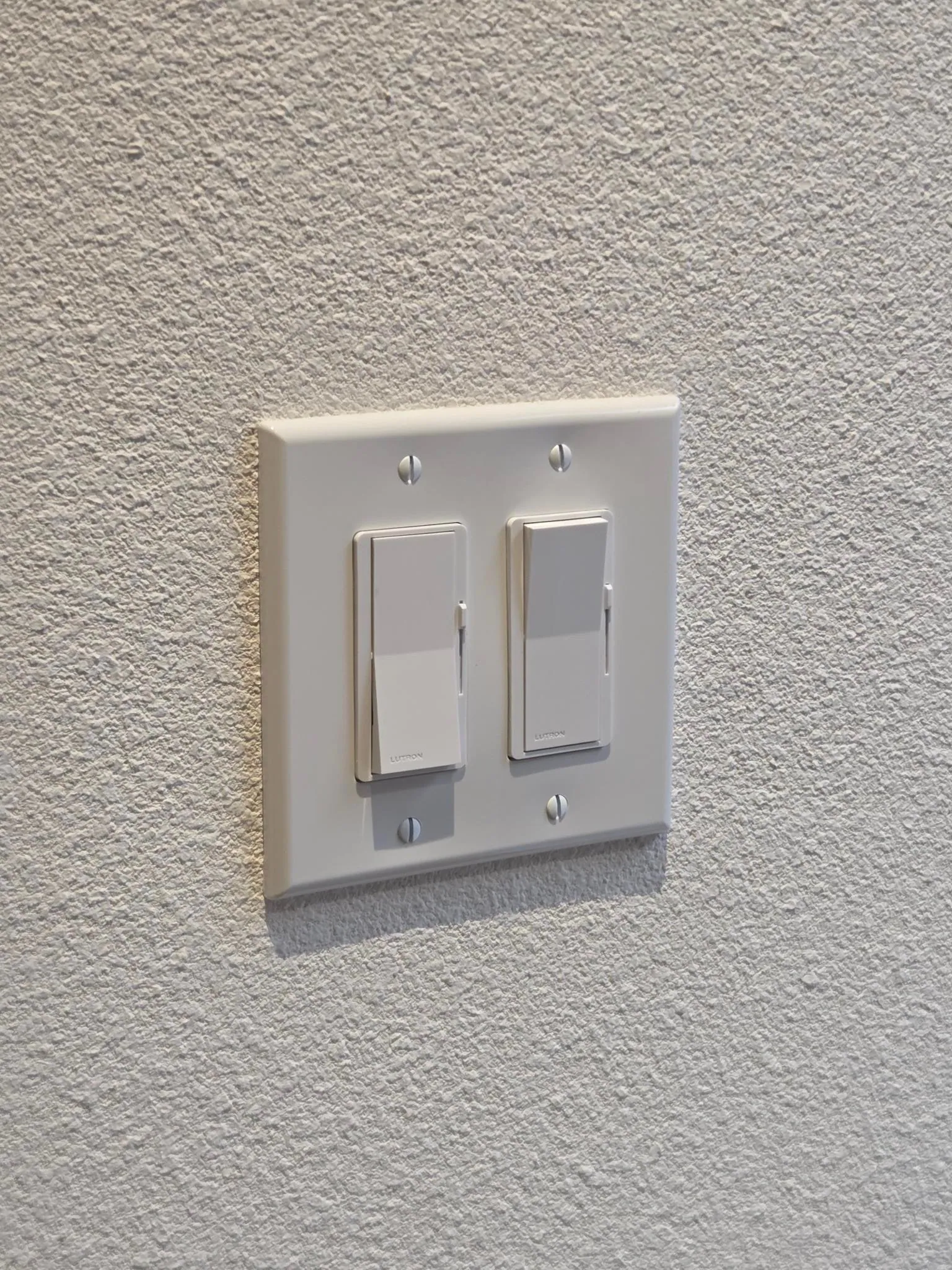 Finished pair of Lutron dimmer switches installed on a residential wall